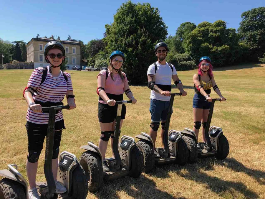 Friends on Segways in the sunshine outside Escot House