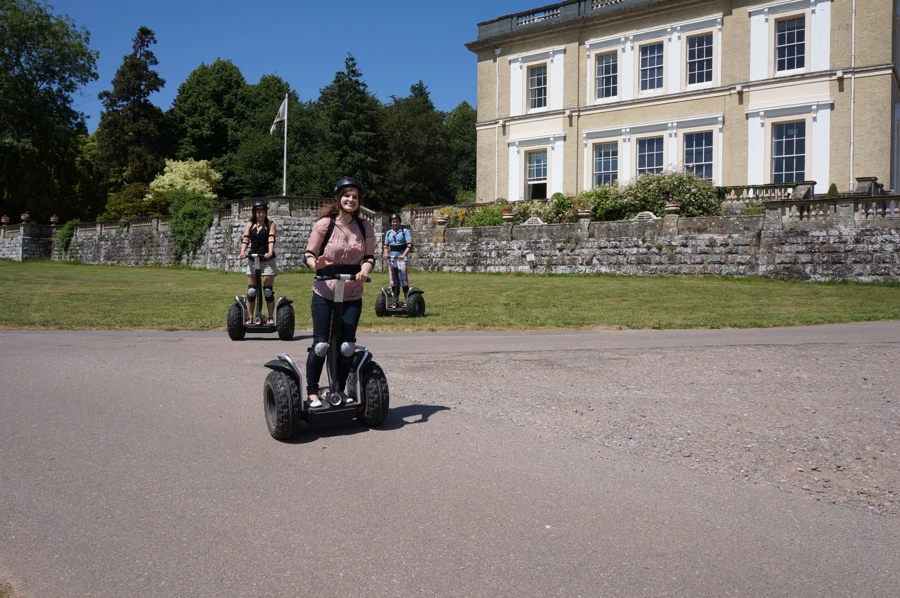 A Segway rider passing Escot House