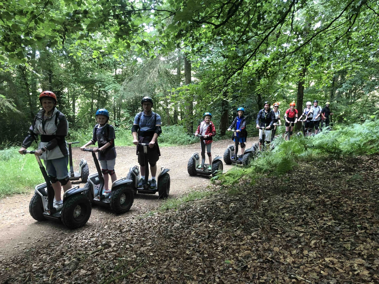 A group riding Segways along a woodland trail on the Escot Estate